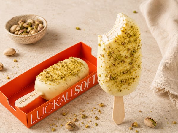 Picolé de pistache com cobertura de chocolate branco e pistache triturado